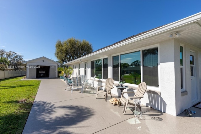 view of patio with a garage, an outdoor structure, and fence