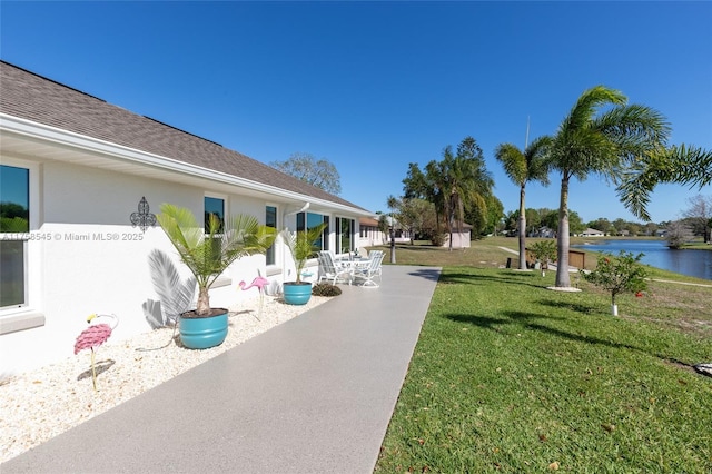 exterior space with a water view, a patio, and a yard