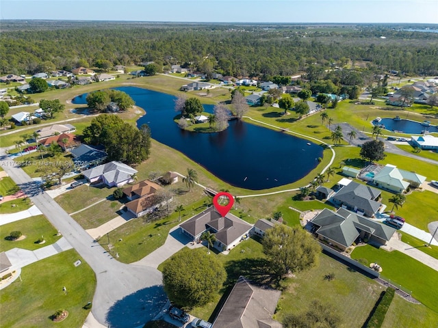 drone / aerial view featuring a water view, a residential view, and a view of trees