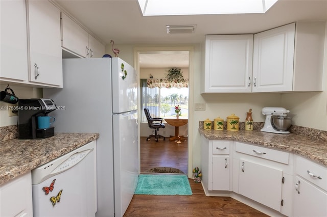 kitchen featuring white dishwasher, wood finished floors, visible vents, white cabinets, and light countertops