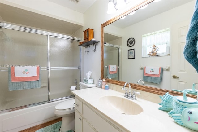 bathroom featuring combined bath / shower with glass door, vanity, toilet, and wood finished floors