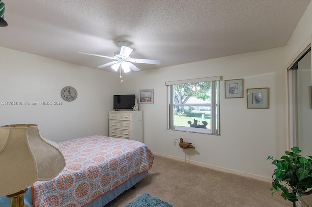 bedroom with a textured ceiling, ceiling fan, carpet, and baseboards