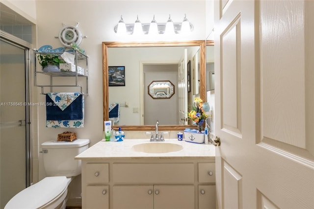 bathroom with vanity, toilet, and a shower with door