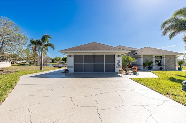 view of front of property featuring an attached garage, driveway, a front lawn, and stucco siding