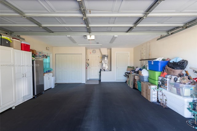 garage with a garage door opener and freestanding refrigerator