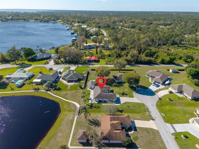 aerial view with a residential view, a water view, and a view of trees