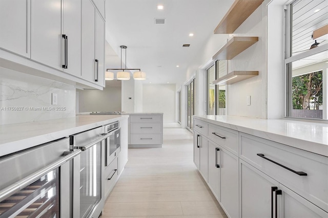 kitchen with tasteful backsplash, visible vents, white cabinets, wine cooler, and open shelves