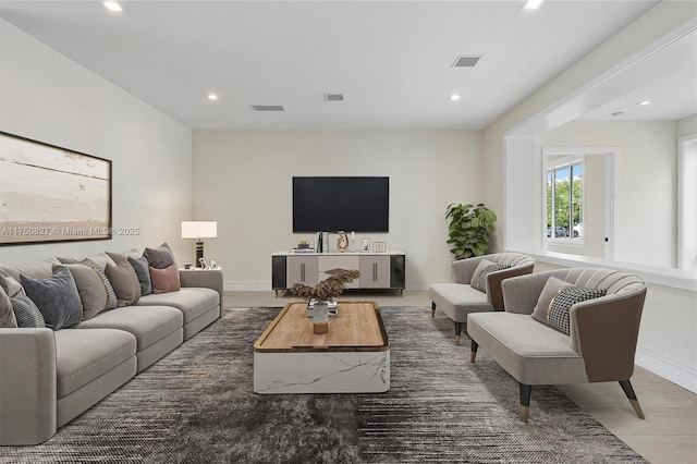 living room featuring baseboards, visible vents, and recessed lighting