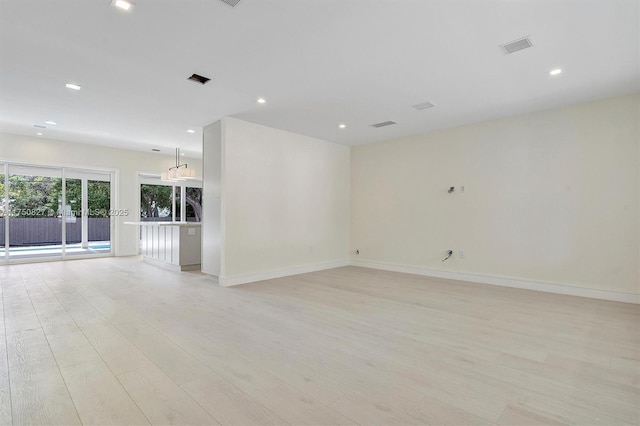 spare room with light wood-type flooring, visible vents, baseboards, and recessed lighting