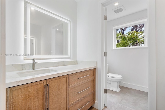 bathroom featuring baseboards, visible vents, toilet, tile patterned floors, and vanity