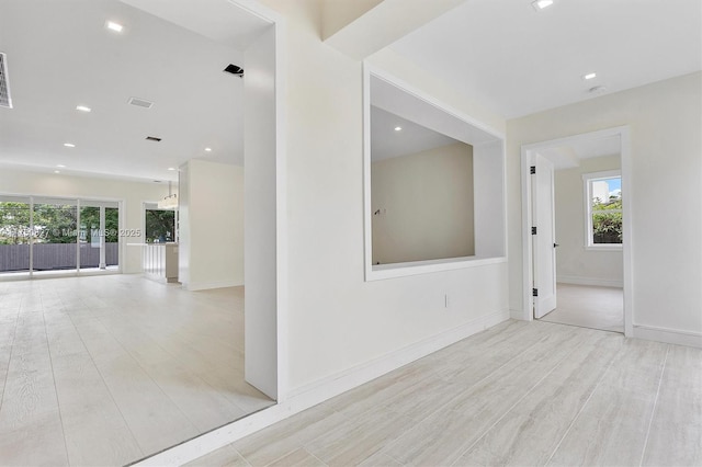 empty room with recessed lighting, wood finished floors, visible vents, and baseboards