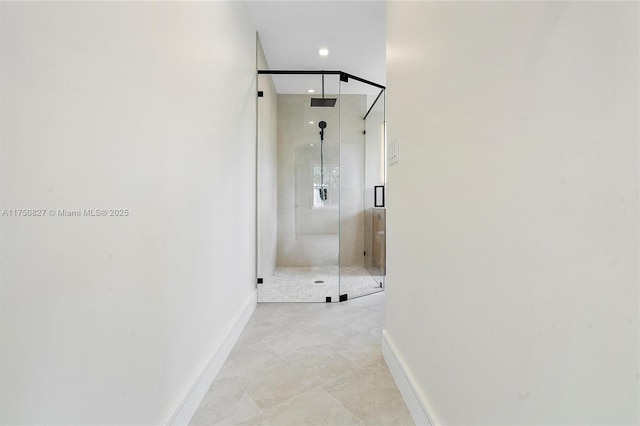 interior space featuring a stall shower and baseboards