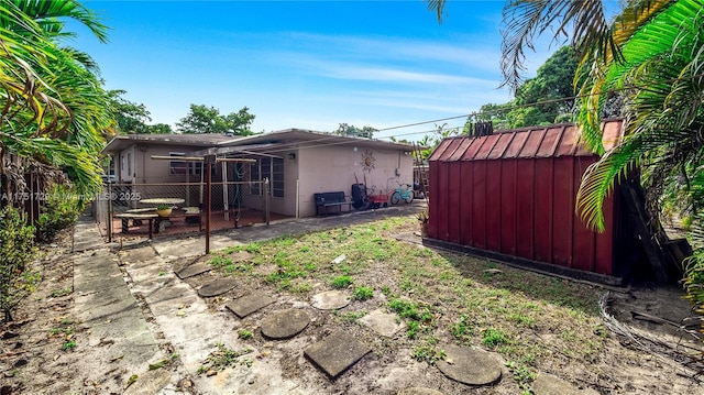 view of yard with a storage shed, a patio area, fence, and an outdoor structure