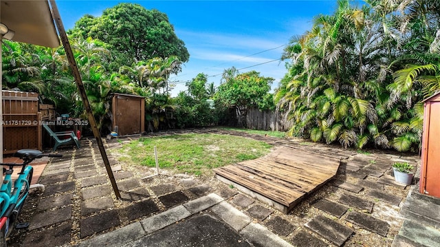 view of yard featuring a patio, an outdoor structure, and a fenced backyard