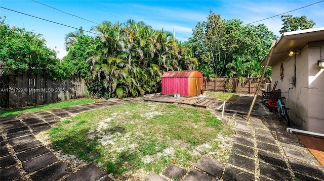 view of yard with a storage shed, an outbuilding, and a fenced backyard