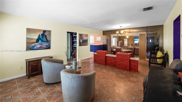 tiled living area featuring baseboards, visible vents, and a notable chandelier