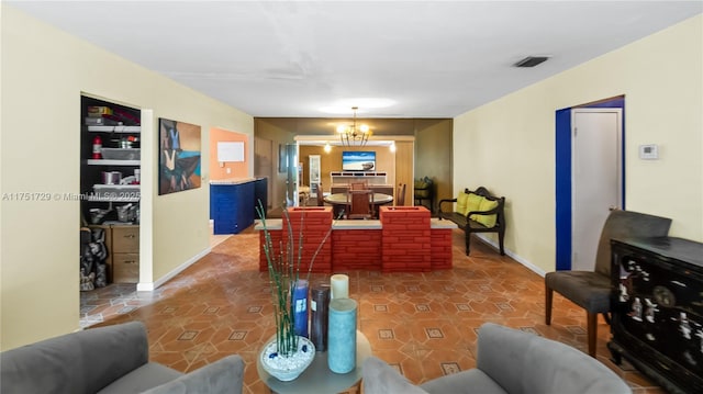 living room featuring a chandelier, tile patterned flooring, visible vents, and baseboards