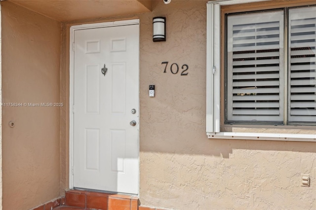 doorway to property with stucco siding