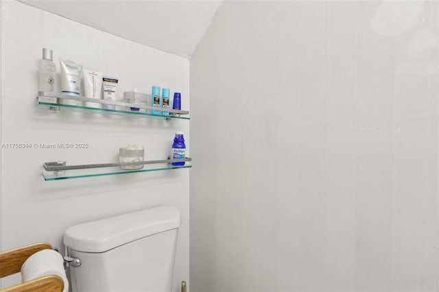 bathroom featuring lofted ceiling and toilet