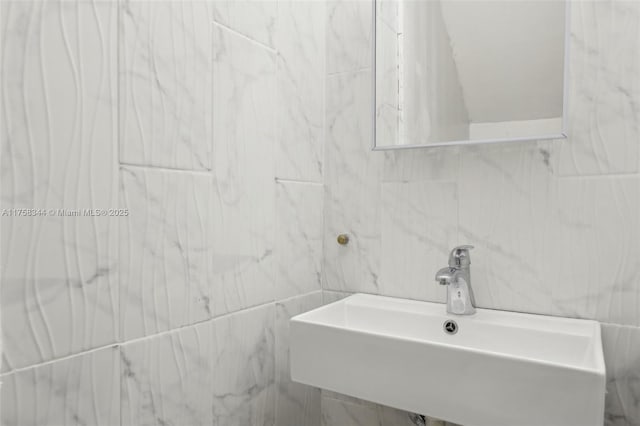 bathroom with a sink and tile walls