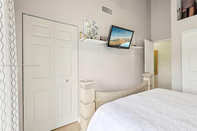 bedroom featuring visible vents, a closet, and wood finished floors