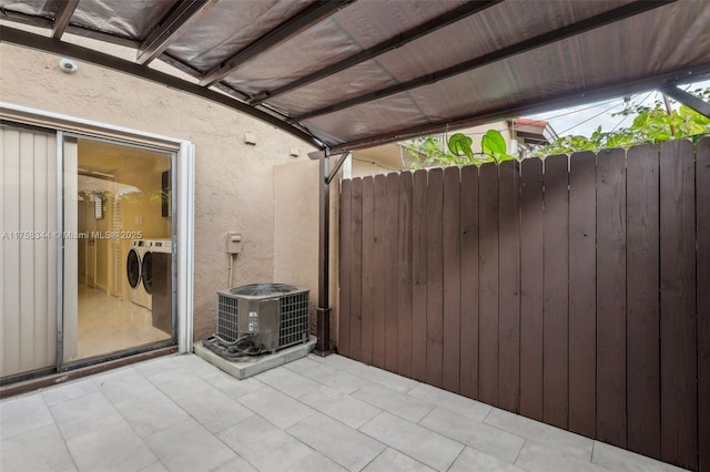 view of patio / terrace with central AC unit, fence, and washer and clothes dryer