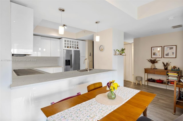 dining area with a tray ceiling, wood finished floors, and visible vents