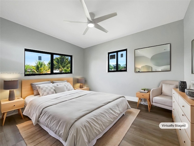 bedroom featuring a ceiling fan, vaulted ceiling, wood finished floors, and baseboards