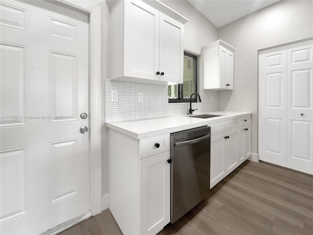 kitchen featuring backsplash, dark wood-type flooring, dishwasher, white cabinetry, and a sink