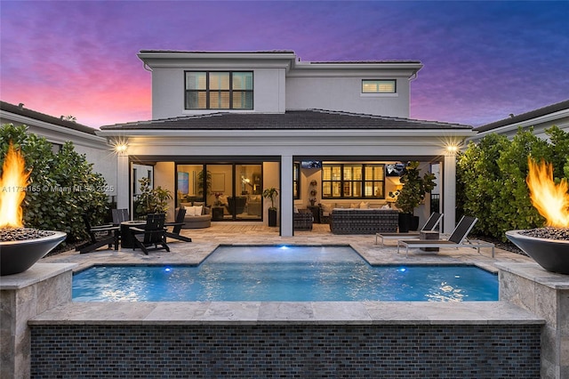 13475 Artisan Cir, Palm Beach Gardens, FL 33418 - rear view of house with an outdoor living space with a fire pit, a tiled roof, a patio area, and stucco siding