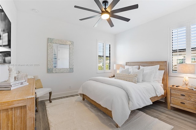 bedroom with a ceiling fan, baseboards, and wood finished floors