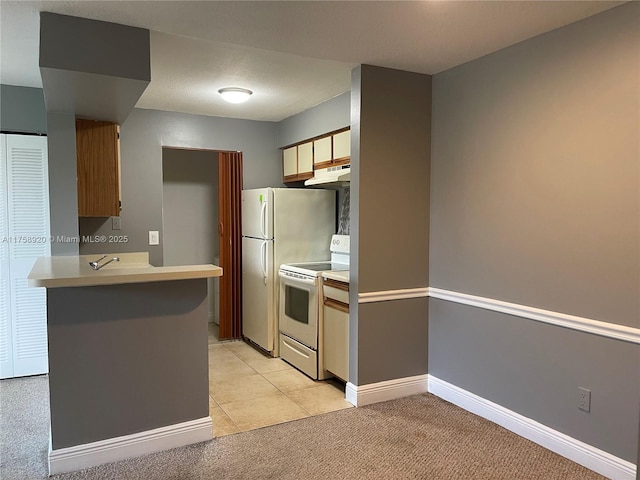 kitchen with light countertops, light colored carpet, a peninsula, white appliances, and under cabinet range hood