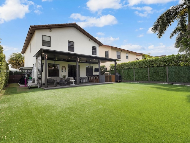 back of property featuring a patio area, stucco siding, a ceiling fan, and a fenced backyard