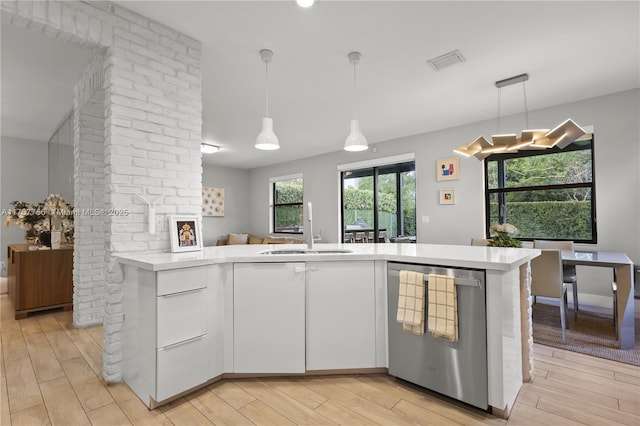 kitchen with visible vents, dishwasher, light countertops, light wood-style flooring, and a sink