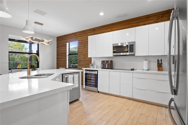 kitchen with wine cooler, a healthy amount of sunlight, appliances with stainless steel finishes, and a sink