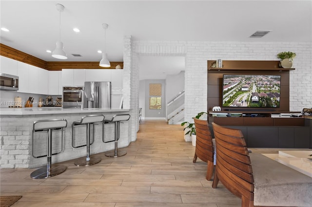 kitchen featuring visible vents, light wood-style flooring, white cabinets, appliances with stainless steel finishes, and modern cabinets