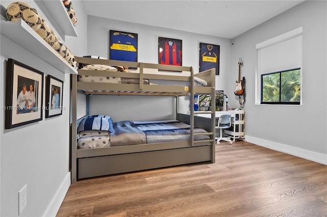 bedroom with wood finished floors and baseboards