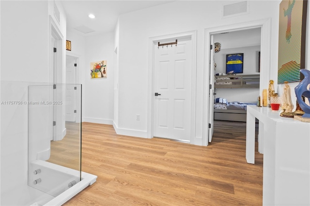 corridor featuring visible vents, recessed lighting, light wood-type flooring, and baseboards