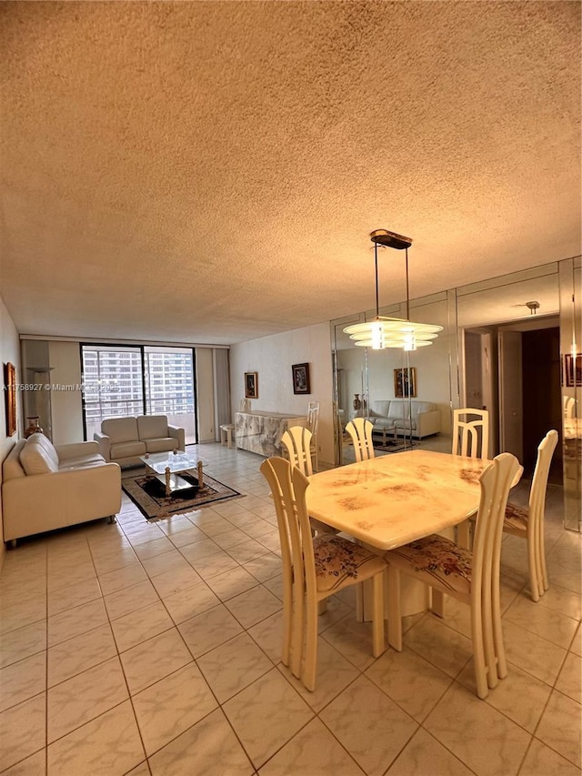 dining area featuring light tile patterned floors, floor to ceiling windows, and a textured ceiling