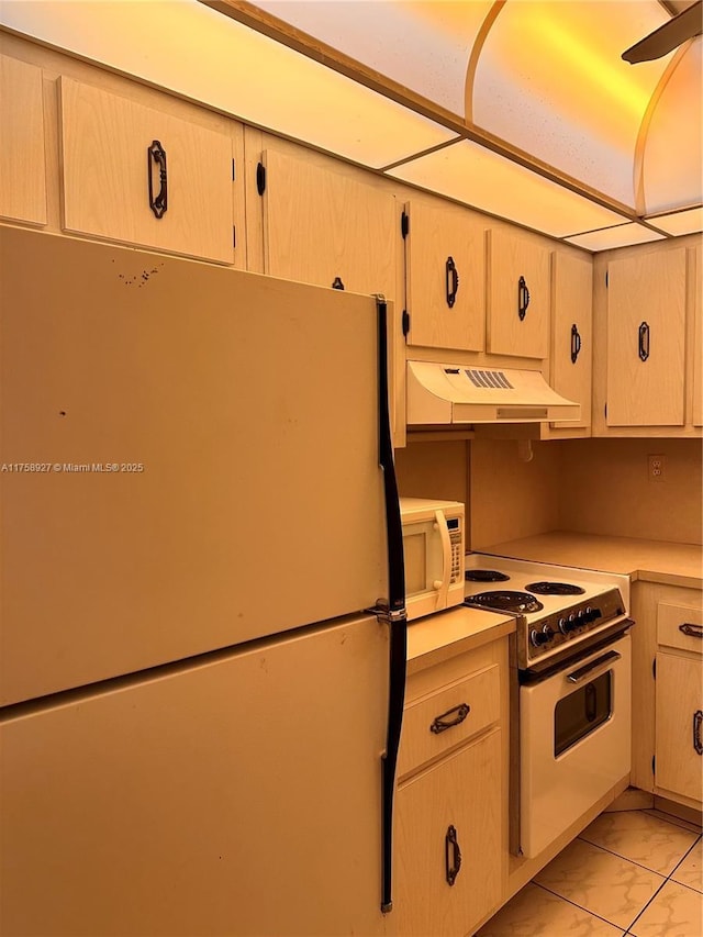 kitchen featuring under cabinet range hood, white appliances, marble finish floor, and light countertops