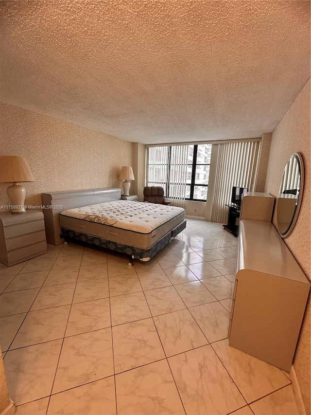 unfurnished bedroom with a textured ceiling and wallpapered walls