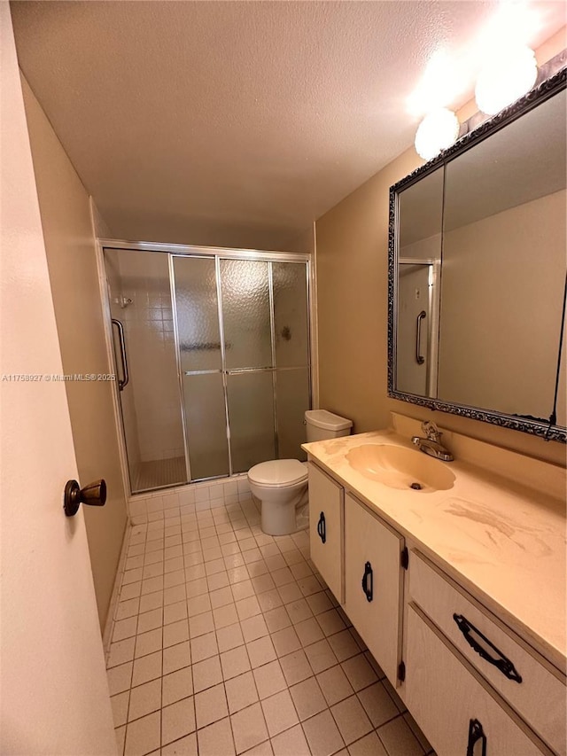 full bathroom with tile patterned floors, toilet, a stall shower, a textured ceiling, and vanity