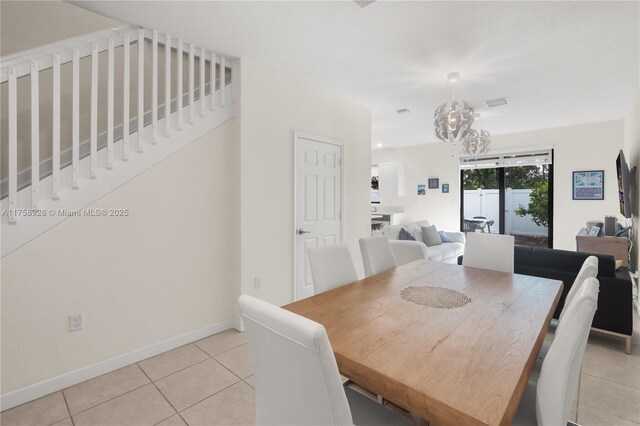 dining space featuring baseboards, a notable chandelier, and light tile patterned flooring