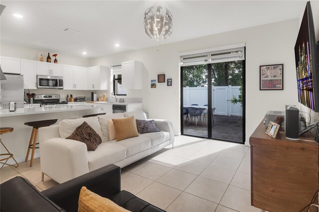 living room featuring recessed lighting, an inviting chandelier, and light tile patterned floors