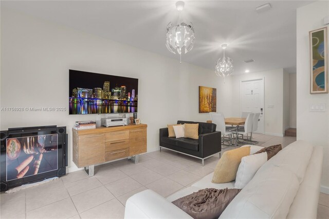 living room with a chandelier and light tile patterned flooring