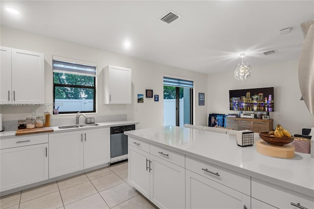 kitchen with a sink, visible vents, light countertops, and dishwasher