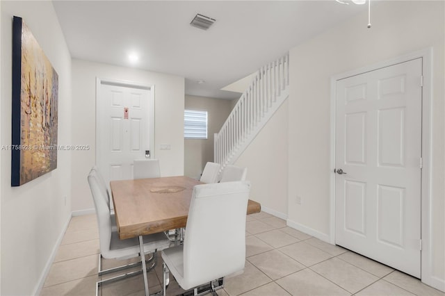 dining area with baseboards, stairs, visible vents, and light tile patterned flooring