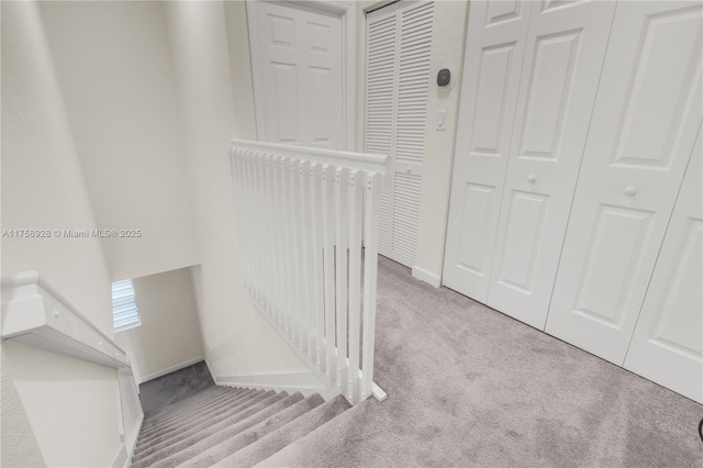 hallway featuring carpet floors and baseboards