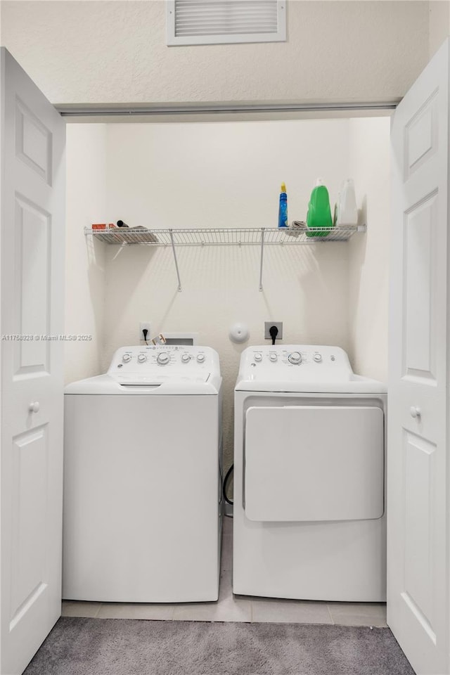 laundry area featuring light tile patterned floors, laundry area, visible vents, and separate washer and dryer