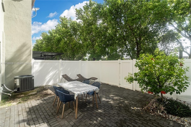 view of patio featuring a fenced backyard, cooling unit, and outdoor dining space